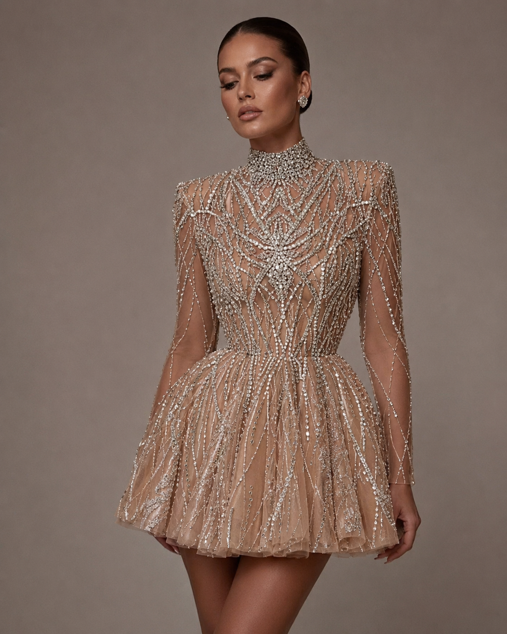 The Celeste — Crystal, from the collar to the hem. A beaded mini on nude illusion mesh with sharp shoulders and a skirt that flares away from the body, made to measure